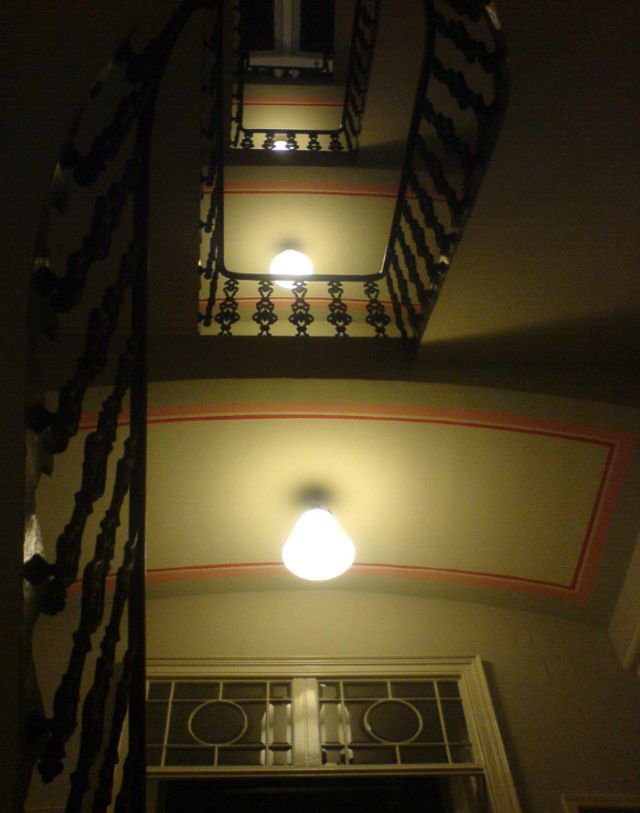 Blick nach oben in ein Gründerzeit-Stiegenhaus mit schmiedeeisernem Geländer